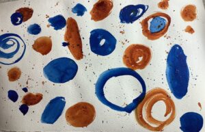 A close up of some blue and brown paint on paper